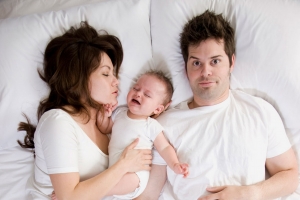 A couple and baby in bed 1